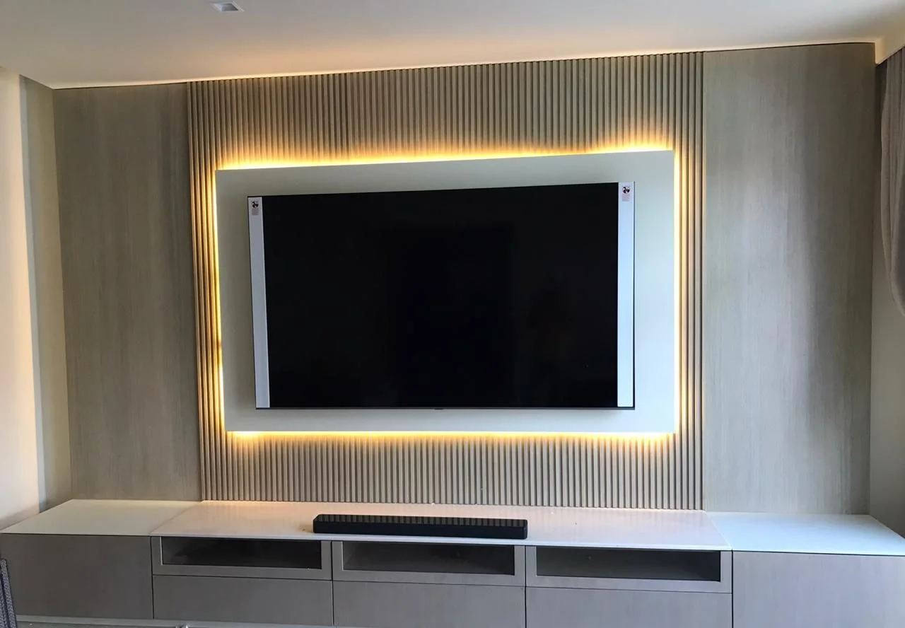 Business Bay apartment: Fluted timber TV wall with a backlit frame