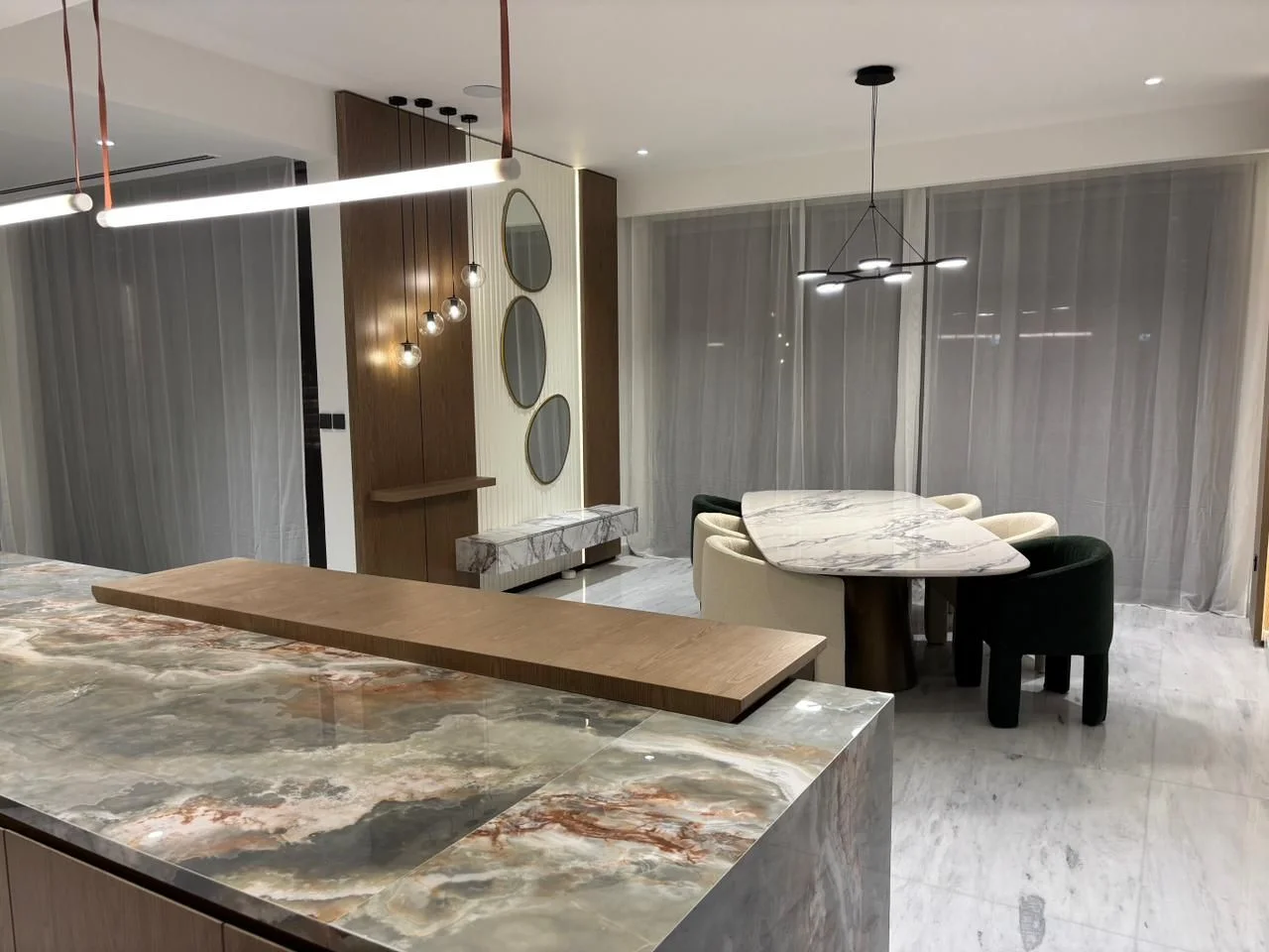Jumeirah Golf Estates villa: Kitchen island in veined stone with a timber breakfast top