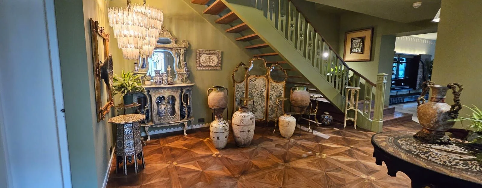 Sur La Mer villa: Hallway with a parquet star floor, chandelier and open staircase