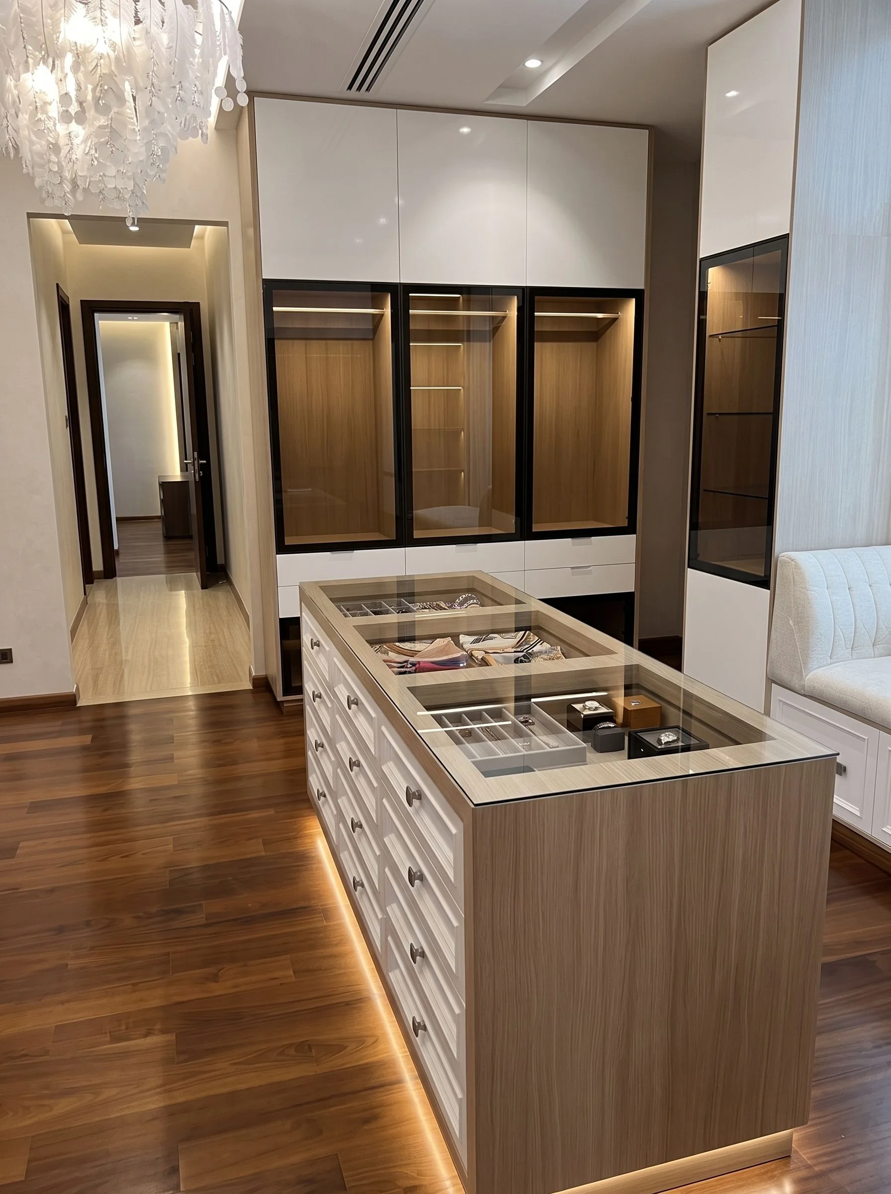Umm Suqeim villa: Dressing room with a glass-topped island and lit shelving